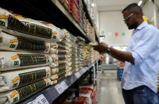 Consumidor vendo preço da farinha de mandioca, produto que a Amas quer incluir na cesta básica nacional (Foto: Álvaro Rezende)