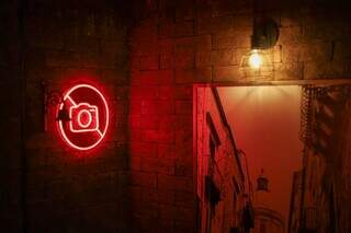 Na entrada do bar, simbolo em neon indica que é proibido utilizar câmeras e celulares (Foto: Henrique Kawaminami)