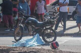 Corpo de Kassiano coberto com lençol, ao lado da moto que ele pilotava (Foto: Marcos Maluf)