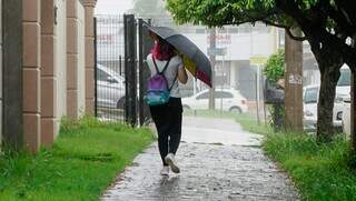 Jovem precisou o guarda-chuva para se proteger na Capital (Foto: Alex Machado)