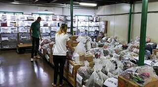 Servidores organizam galpão onde estão armazenados os produtos para o leilão da Sefaz (Foto: divulgação)
