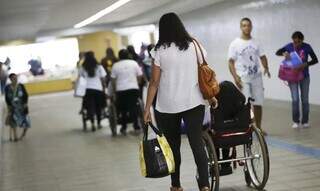 Mulher acompanha pessoa com deficiência física ou com mobilidade reduzida temporariamente (Foto: Marcelo Camargo/Agência Brasil)