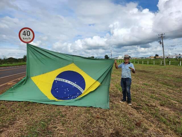 Com bandeira e bucha na m&atilde;o, Gilto leva protesto silencioso para frente da JBS