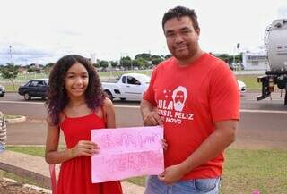 Motoboy segura o tereré (imagem 1) e um cartaz junto à filha (imagem 2) (Fotos: Paulo Francis)