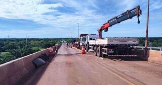 Caminhões utilizados para manutenção da estrutura ocupam meia pista da ponte (Foto: Seilog)