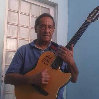 Antonio Manoel Pereira Guimarães, mais conhecido como Caxingue, posa com seu principal instrumento: o violão (Foto: Arquivo pessoal)