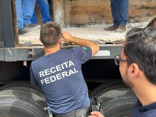 Servidor da Receita Federal abrindo fundo falso da carreta (Foto: Divulgação/Receita Federal)