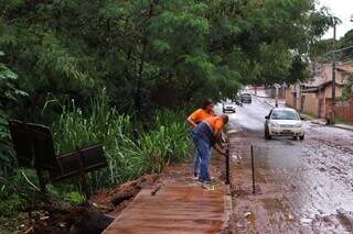 Agentes da Defesa Civil sinalizam buraco aberto pela chuva na ponta da Rua Catiguá (Foto: Paulo Francis)