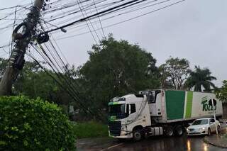 O caminhão ficou enroscado nos fios e o poste ficou torto (Foto: Direto das Ruas)