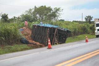 Caminhão tombado e parte da carga caída às margens da rodovia (Foto: Marcos Maluf)