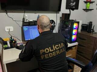 Policial no cumprimento de busca e apreensão (Foto: Divulgação/PF)