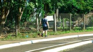 Cidadão passeia com cachorro de pequeno porte no Parque das Nações Indígenas, na tarde desta quinta. (Foto: Alex Machado)