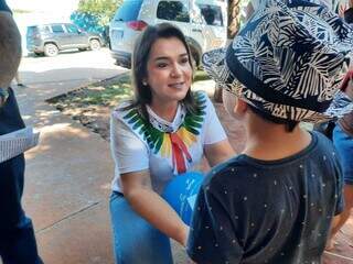 Prefeita Adriane Lopes (PP) conversa com criança durante mutirão Todos em Ação, no Bairro Nova Campo Grande. (Foto: Caroline Maldonado)