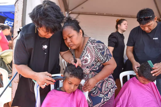 Criança indígena recebe corte de cabelo em ação social da prefeitura. (Foto: Reprodução/SDHU)