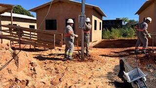 Funcionários da Energisa instalando padrão de energia em novas residências do Mandela (Foto: divulgação PMCG)