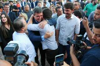 Governador Eduardo Riedel (PSDB) é abraçado por prefeito de Nioaque, Valdir Couto, na chegada ao evento (Foto: Juliano Almeida)