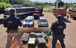 Policiais sobre caminhão que levava 12 toneladas de maconha cobertas por terra (Foto: Divulgação)