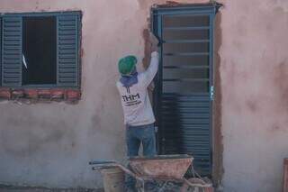 Trabalhador rebocando parede para instalar porta de ferro em casa popular no José Tavares (Foto: Marcos Maluf)
