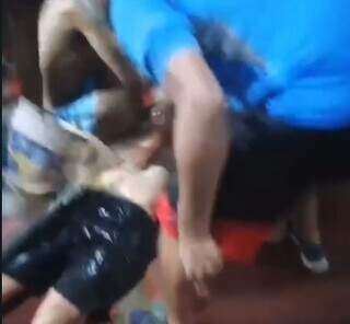 Momento que preso é socorrido por colegas, que despejam balde de água sobre ele (Foto: Vídeo/Reprodução)