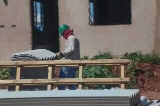 Trabalhador pegando telha em obra de casa popular, no Bairro José Tavares (Foto: Marcos Maluf)