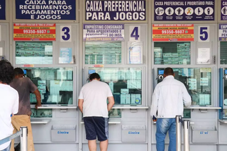 Apostadores são atendidos em guichês de agência lotérica. (Foto: Arquivo/Henrique Kawaminami)