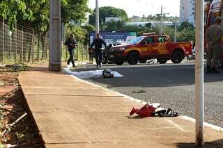 Parte da motocicleta, capacete e vítima caída na rua após acidente (Foto: Osmar Veiga)