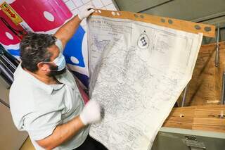 Douglas segurando mapa antigo de Corumbá. (Foto: Henrique Kawaminami)