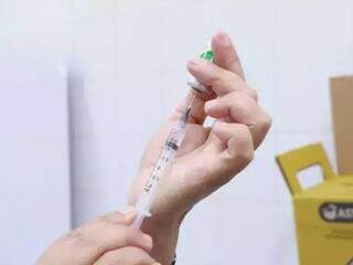 Profissional da saúde manipula ampola da vacina contra a gripe, em unidade básica de saúde. (Foto: Arquivo/Campo Grande News)