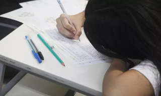 Jovem estudante resolve equações durante aplicação da Obmep. (Foto: Alexandre Campbell/Agência Brasil)