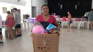 Luciene veio de moto e comprou mais do que previa; vai ser difícil levar para casa na caixa (Foto: Izabela Cavalcanti)