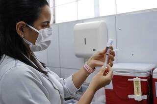 Enfermeira prepara imunizante da gripe, dentro da sala de vacinação de posto de saúde (Foto: Paulo Francis)