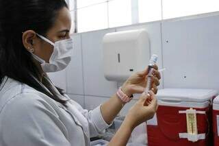 Profissional manipula vacina contra a gripe em unidade de saúde de Campo Grande. (Foto: Paulo Francis)