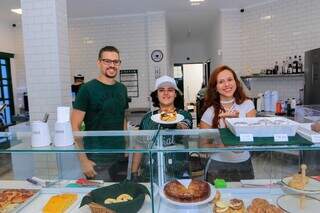 Afonso, à esquerda, e Fabianny, à direita, e funcionária da cafeteria no centro, apresentam vitrine de doces (Foto: Paulo Francis)