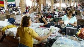 Voluntários realizam a separação das doações de roupas recebidas (Foto: Alex Machado)