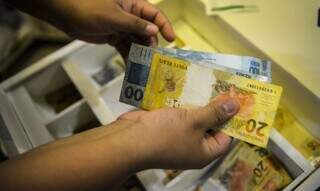Pessoa conta cédulas de dinheiro. (Foto: Marcello Casal Jr/Agência Brasil)