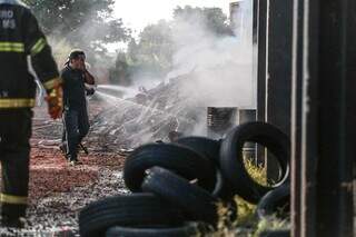 Bombeiros tentam conter fogo em materiais de depósito (Foto: Marcos Maluf)