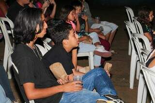 Crianças e adolescentes concentrados no filme exibido em telão ao ar livre (Foto: Juliano Almeida)