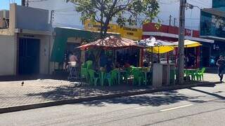 Consumidores sentados em frente a lanchonete, na Rua Barão do Rio Branco, em Campo Grande (Foto: Antonio Bispo)