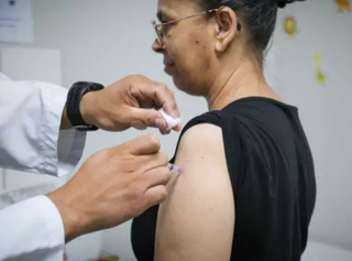 Moradora de Campo Grande se vacinando no Dia D contra gripe (Foto: Henrique Kawaminami)