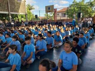 Alunos sentados em formação durante evento na escola do bairro Guanandi. (Foto: Fernanda Palheta)