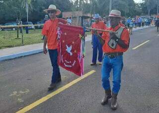 À esquerda, Bertoldo carrega a bandeira em sua última participação na Festa do Divino Espírito Santo, em 2023 (Foto: Arquivo Pessoal)