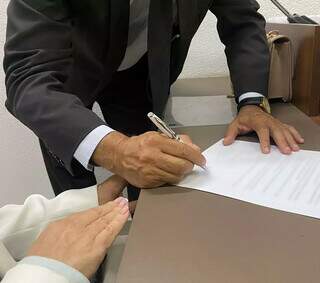 Advogado assinando documento na Ordem dos Advogados do Brasil, seccional Mato Grosso do Sul (Foto: Clara Farias)