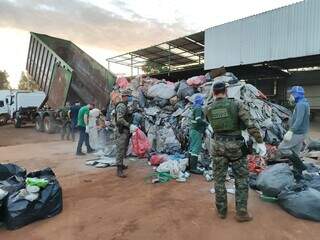 Policiais vistoriando caminhão carregado com lixo reciclável (Foto: Divulgação)