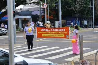 Voluntários levantavam faixa ‘Uma hora = três crianças abusadas sexualmente no Brasil&#39;, em pedágio de conscientização a campanha Maio Laranja na Avenida Afonso Pena, neste sábado (18) (Foto: Paulo Francis)