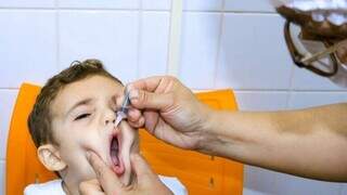 Criança tomando gotinha que imuniza contra a Poliomielite (Foto: Divulgação/Sesau)
