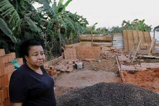 Silvia Márcia mostra restos de materiais após ter casa em construção derrubada (Foto: Paulo Francis)