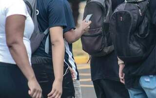 Adolescente checando o celular em saída de escola no Centro de Campo Grande (Foto: Marcos Maluf)