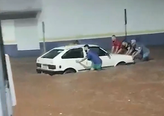 Moradores empurram carro em enchente ocorrida em abril em Ivinhema (Foto: Aconteceu MS)