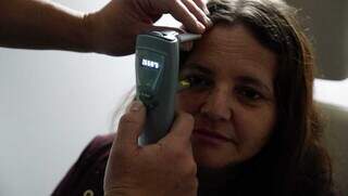 Paciente passa pelo exame que mede a pressão ocular (Foto: Alex Machado)