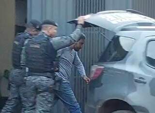Momento em que Fabiano Garcia Sanches, de 38 anos, é colocado em camburão do Batalhão de Choque para ser levado preso à Deam (Foto: Vídeo do Campo Grande News/Reprodução)